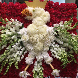 Red and white floral arrangement shaped like a teddy bear