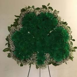 Large green floral wreath on a standing easel with white filler flowers