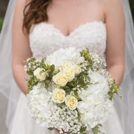 Bride holding a white bouquet with roses and hydrangeas