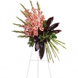 Pink floral spray on a white easel stand