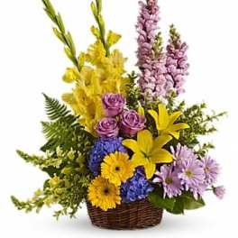 Basket arrangement with yellow lilies, purple roses, and lavender daisies