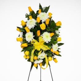 Yellow roses and white chrysanthemums on a standing easel with yellow ribbons