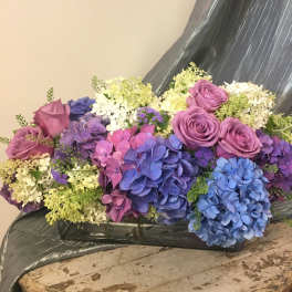 Bouquet of purple roses and blue hydrangeas with white filler flowers