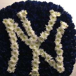 Large floral wreath with white flowers arranged as the letters NY