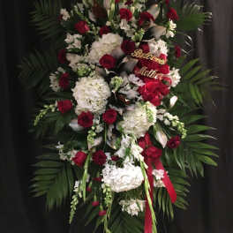 Large standing floral spray with red and white flowers and a red ribbon