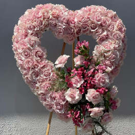 Heart-shaped pink rose floral display on an easel