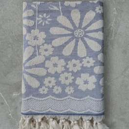 Folded blue and white floral-patterned textile with tassel fringe