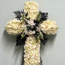 White rose cross-shaped floral tribute on an easel