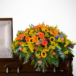 Bright mixed flower spray on a casket