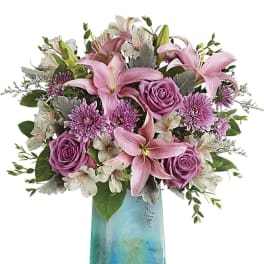 Pink lilies and roses in a blue glass vase