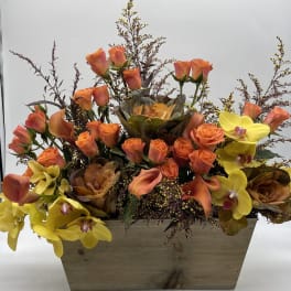 Orange roses and yellow orchids arranged in a wooden box