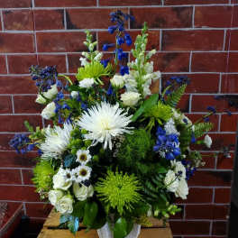 Large bouquet of white and blue flowers in a white vase