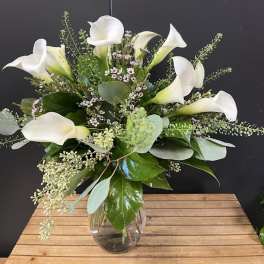 White calla lily bouquet in a clear glass vase