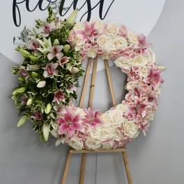 Pink and white floral wreath on a wooden easel