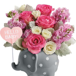 Pink and white roses in a gray elephant vase with a "Hello Baby!" sign