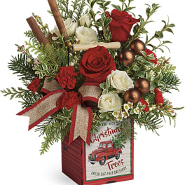 Christmas floral arrangement in a red wooden box with roses and ribbon