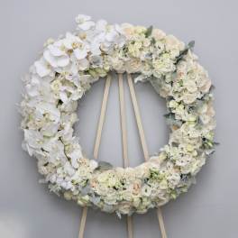 Large white floral wreath on a wooden easel