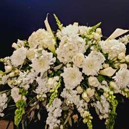 Large white funeral spray with lilies, carnations, and snapdragons