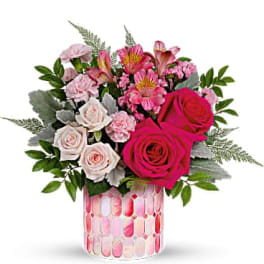 Pink and white rose bouquet in a patterned glass vase