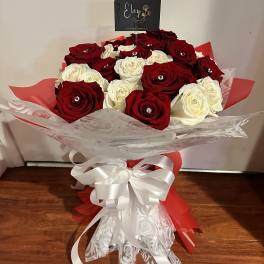 Bouquet of red and white roses wrapped with a white ribbon