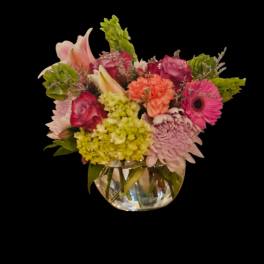 Mixed pink and green flower arrangement in a clear glass vase
