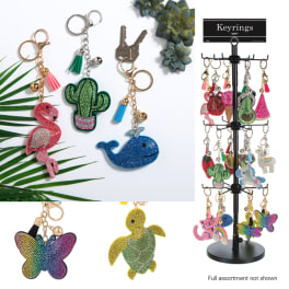 Assorted rhinestone keychains with animal and fruit charms on a display stand