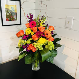 Bright mixed flower arrangement in a clear glass vase