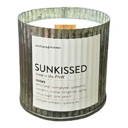 Scented candle in a woodgrain tin labeled Sunkissed