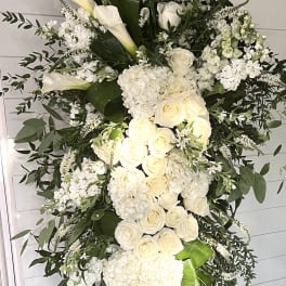 Tall white floral standing spray with roses and calla lilies