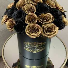 Black and gold bouquet of roses in a tall round box