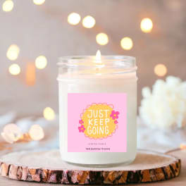 Scented candle in a glass jar with a pink label