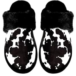 Pair of black-and-white cow-print slippers with fuzzy cuffs