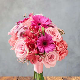 Pink bouquet of roses, gerbera daisies, and carnations on a stand