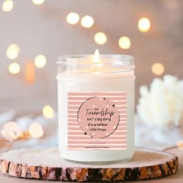 Scented candle in a glass jar with a pink friendship label