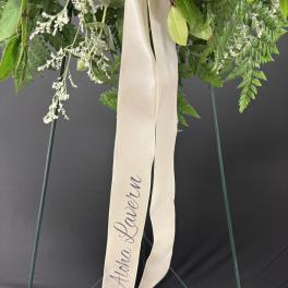 Green floral wreath with a cream ribbon reading "Aloha Lauren"