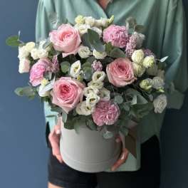 Pink and white flowers arranged in a round hatbox