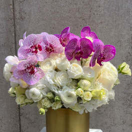 White roses and pink orchids in a gold vase