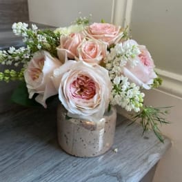 Pink roses arranged in a small ceramic vase