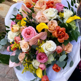 Mixed bouquet of roses, tulips, calla lilies, and anthurium in white wrap