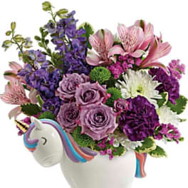 Bouquet of purple, pink, and white flowers in a unicorn-shaped vase