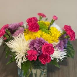 Colorful mixed bouquet in a square glass vase