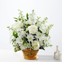 White roses and daisies arranged in a woven basket
