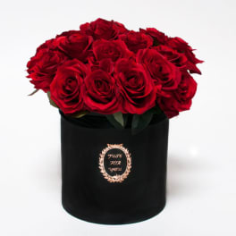 Red roses arranged in a black cylindrical box