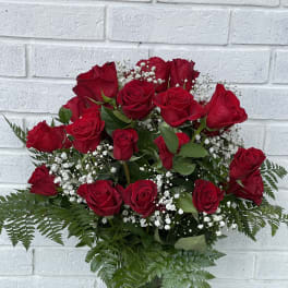 Bouquet of red roses with baby's breath in a glass vase
