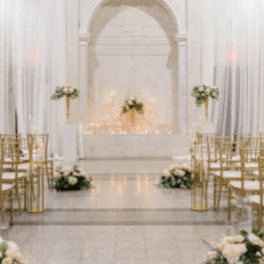 White floral wedding aisle with gold chairs and altar arrangements