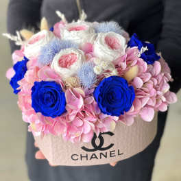 Pink and blue floral arrangement in a Chanel box