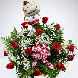 Basket arrangement of red roses with a heart balloon and ribbon