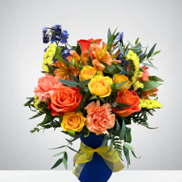 Colorful bouquet of roses, carnations, and alstroemeria in a blue vase