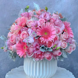 Pink rose and gerbera daisy arrangement in a white vase