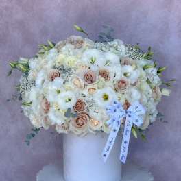Large white and blush bouquet in a white vase with a ribbon bow